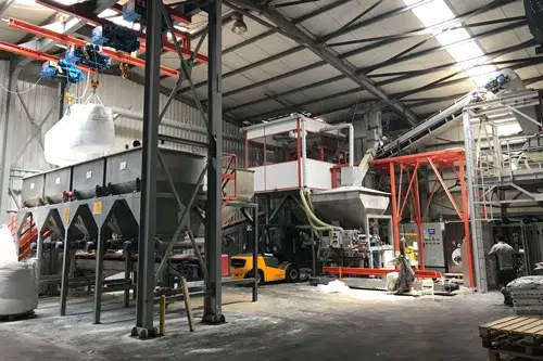 Industrial material handling and processing system installed inside a factory facility